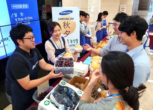 Samsung C&T officials purchase special products at a direct-trading market. (File photo of Samsung C&T)