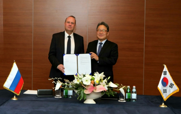 Hyundai Engineering President Kim Chang-hak (right) and Gaz Sintez President Andrei Kaliningin take photos after signing the contract at a signing ceremony in Moscow on April 25 (local time).