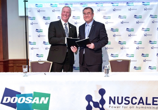 Na Ki-yong, head of Doosan Heavy's nuclear power center (right) and John L. Hopkins, CEO of Nuscale Power, are taking a photo while holding up the agreement after signing the MOU on April 29(local time) at the signing of a memorandum of understanding to cooperate on the Small Modular Reactor project of NuScale Power.