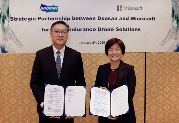 이두순 두산모빌리티이노베이션 대표(사진 왼쪽)가 우미영 한국마이크로소프트 부사장과 미국 라스베이거스에서 ‘수소연료전지 드론 솔루션 개발’을 위한 협약을 맺고 있다/ 두산 제공
